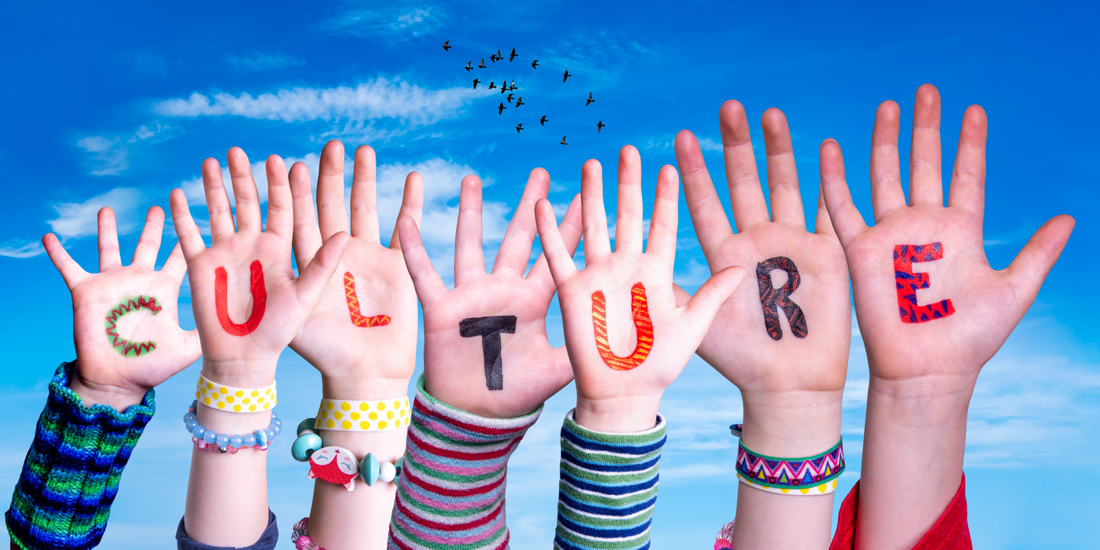 Image of school kids' hands with letters painted to spell "culture."